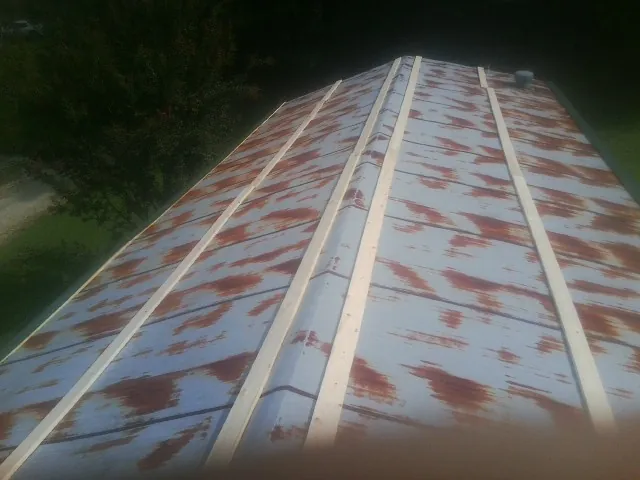 Rusted metal roof panels with new wood purlins before replacement — Storm Damage Roof Repair in Pinckneyville by Roofing Brothers