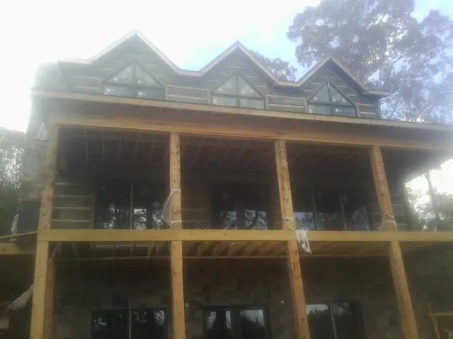 Dormers and porch framing on a large log home under construction — Roof Coating work by our crew in Pinckneyville