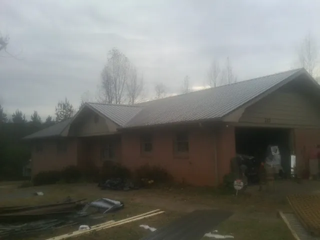 Gray metal roof on a stucco house with an attached garage in Pinckneyville