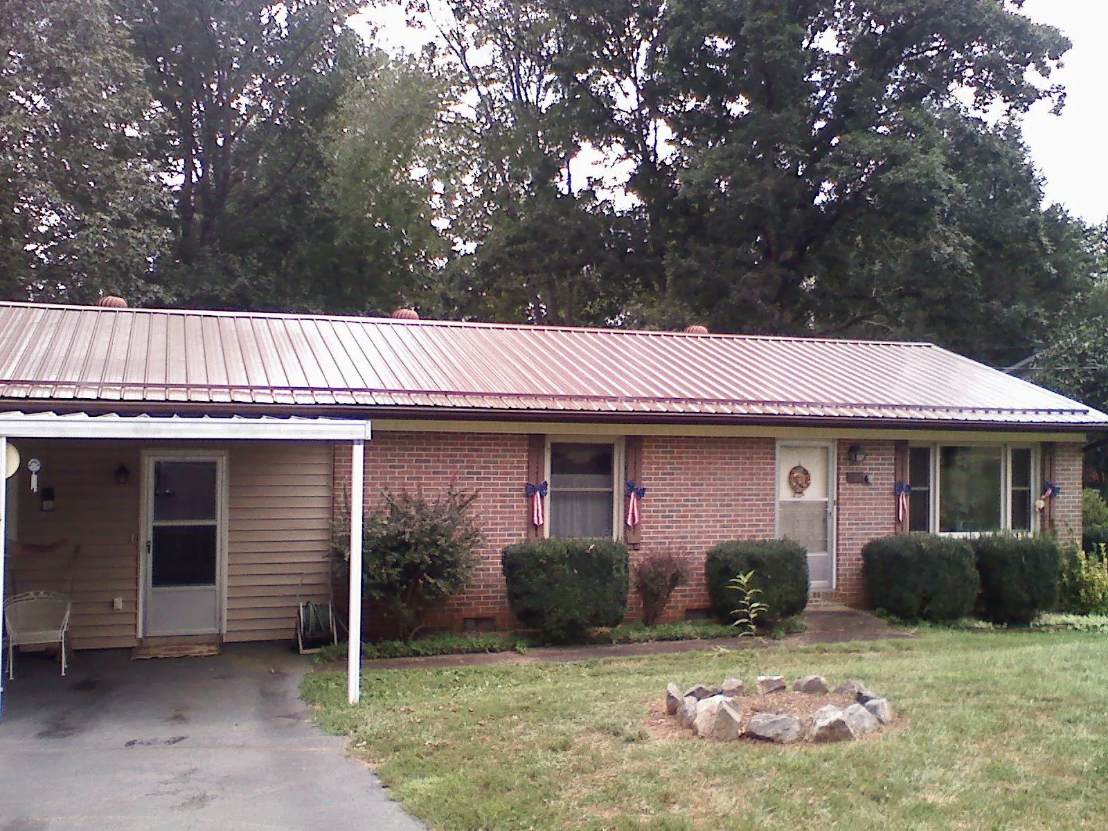 Bronze metal roof and carport on a brick ranch home — Roof Repair work by our crew in Pinckneyville